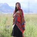 Ethnic style hooded knit poncho shawl outdoor scene detail, cozy autumn winter apparel. - African Style Hooded Poncho, Red & Blue