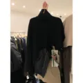Vista dettagliata del poncho in maglia nera a collo alto con orlo asimmetrico da donna. - Taglia unica / Nero