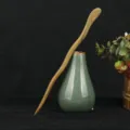Detailed view of the natural green sandalwood hairpin showcasing smooth wood grain and shape. - Good Times