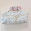 Dettaglio di borsa portaoggetti trapuntata a quadri blu, elegante trousse da viaggio. - Quadri Blu Chiaro