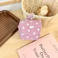 Detailansicht einer rosa Kord-Kosmetiktasche mit weißen Punkten, Herzschnalle und Tragegriff. - Rosa Punkt