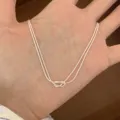 Gros plan sur le collier en chaîne serpent double en argent avec un détail de nœud élégant. - Style Noué Double Couche (MY35359) / Argent