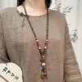 Lange houten kralen trui ketting met etnische lotus hanger en kleurrijke accentkralen. - Hout