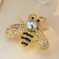 Gros plan détaillé d'une broche abeille de luxe avec strass, perles et finition dorée. - Base Bronze Gris