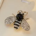 Vue détaillée d'une broche abeille élégante ornée de strass scintillants et perle. - Base Argent Noir