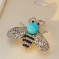 Exquise broche abeille en cristal avec strass scintillants et perle bleue vibrante. - Bleu À Base Argentée