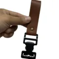 Metal glove clip detail showing durable brown leather strap and black tactical buckle. - Brown