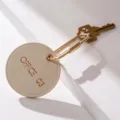Minimalistischer runder Leder-Schlüsselanhänger mit Messing-Karabiner und Schlüssel, stilvoll. - Weiß