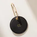 Minimalistischer runder schwarzer Leder-Schlüsselanhänger mit goldenem Messingverschluss. - Schwarz