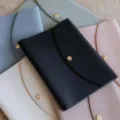 Detailansicht bunter PU-Leder Notizbuchhüllen mit eleganten goldenen Druckknopfverschlüssen. - Schwarz