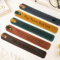 Close-up of colorful PU leather bookmarks with custom engraved quotes and buttons. - Dark Brown