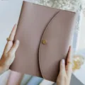 Nahaufnahme der eleganten graurosa PU-Leder Notizbuchhülle mit Druckknopfverschluss. - Lotosrosa