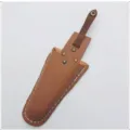 Detalle de funda de cuero para tijeras, bolsa de herramientas marrón con botón a presión y costuras. - Marrón