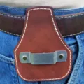 Dettaglio ravvicinato di una custodia portautensili in pelle marrone con clip in metallo. - Marrone scuro
