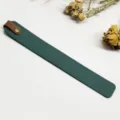 Detalle en primer plano del marcapáginas de cuero PU verde oscuro con trabilla marrón y remache. - Verde y Marrón Oscuro