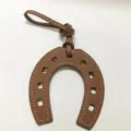 Brown leather horseshoe bag charm with white stitching elegant handbag pendant accessory - Brown