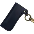 Detail des dunklen Leder-Feuerzeugetuis mit Retro-Bronzeschlüsselring und feiner Naht. - Schwarz