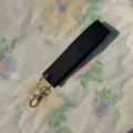 Black PU leather wristlet keychain strap with gold metal hardware, perfect for keys and bags. - Black