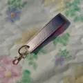 Pink PU leather wristlet keychain with gold metal clasp and ring, stylish strap for keys and bags. - Champagne