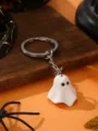 Close-up of a cute white ghost keychain with metal ring, Halloween spooky style pendant detail. - Ghost / White