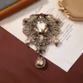 Vintage rhinestone hollow flower brooch with teardrop glass pendant for winter coat accessory. - Antique Gold Champagne