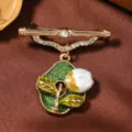 Vintage goudkleurige broche met groene geemailleerde bladhanger en sprankelende strass steentjes voor dames. - Romeinse Stang Hangende Tulp