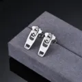 Stainless steel zipper shape earring detail close-up, minimalist silver metal design showcase. - Steel