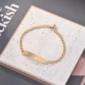 Detailansicht eines modischen goldenen Edelstahlarmbands mit hohlem Schmetterling und Namensschild. - Goldenes Schmetterling Armband Mit Gebogener Platte