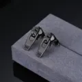 Detailed view of black zipper stud earrings made of stainless steel with a unique minimalist style. - Black