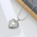 Close-up detail of vintage stainless steel heart locket necklace with floral engraved pattern. - Hollow Rose Heart (Style 1)