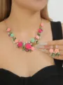 Close-up detail shot of the elegant enamel camellia floral necklace and matching earrings set. - AB Color Set