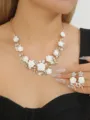 Close-up shot of elegant white camellia flower rhinestone pearl necklace and earrings set. - Pure White Set