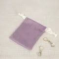 Violetter Samt-Schmuckbeutel mit weißer Kordel und eleganten Ohrringen Detailansicht. - Hellviolett