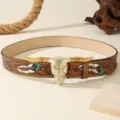 Western vintage leather belt with bull skull buckle and detailed feather carving for men. - Camel