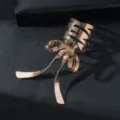 Primo piano di un elegante fermaglio per capelli dorato con un grazioso design a fiocco. - Oro