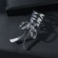 Vista dettagliata del polsino per capelli con fiocco metallico argentato, accessorio elegante. - Argento