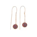 Close-up of long rose gold threader earrings featuring vibrant colorful round glitter pendants. - Colorful