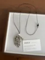 Detailed shot of vintage natural stone pendant necklace with adjustable black cord on tray. - Spotted Stone Grape Cluster Style (XL5713B)