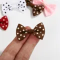 Close-up of mini polka dot grosgrain ribbon bows showing scale on fingers - Polka Dot Bow / Brown