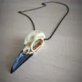 Dettaglio in primo piano della collana con ciondolo teschio di corvo in resina in stile gotico. - Catena Nera