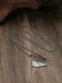 Collana con ciondolo bara gotica con dettaglio scheletro smaltato rosso su sfondo di legno. - Argento Antico