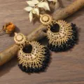 Close up shot of bohemian gold hollow carved earrings featuring elegant black beaded fringes - Black & Gold Tone