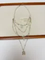 Detailed shot of multi-layer pearl and gold chain necklace with moon pendant, elegant jewelry. - Gold Horseshoe Style (XL3227) / Gold