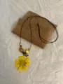 Detail shot of the resin yellow flower pendant necklace featuring wooden beads and long cord. - Yellow Galsang Flower Style