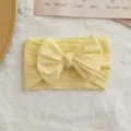 Banda para bebé amarilla clara con punto de ochos, lazo grande y ajuste elástico. - Estilo de Lazo Torcido / Amarillo claro
