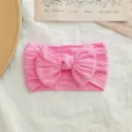 Diadema elástica de nailon rosa para bebé con lazo grande de punto trenzado. - Estilo de Lazo Torcido / Rosa