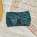 Diadema para bebé con lazo de punto trenzado en color verde azulado. - Estilo de Lazo Torcido / Verde Oscuro