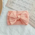 Diadema elástica para bebé color melocotón con lazo grande y textura de punto trenzado - Estilo de Lazo Torcido / Naranja claro