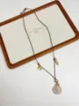 Detail shot of bohemian ocean style seashell necklace with adjustable leather cord on wooden tray. - Shell Style (XL3201C)