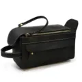 Detail view of black leather toiletry bag with zipper and handle, showcasing fine stitching. - Black